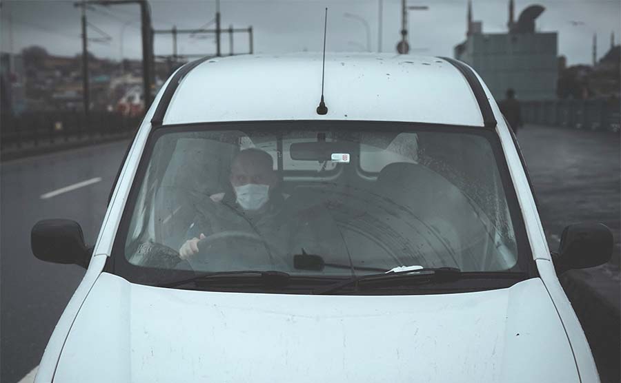 Man driving with a Covid mask